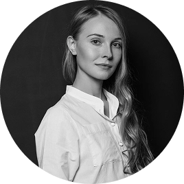 Zwart-witportret van een vrouwelijke professional met lang haar, weergegeven in een ronde lijst tegen een zachtgroene achtergrond.